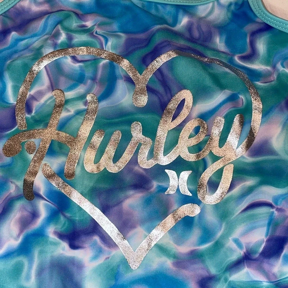 Hurley girls swim one piece. Trimmed in green with swirls of blue/purple. GGG